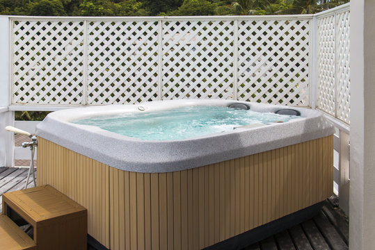 Wooden bathtub with swirling water at outdoor.