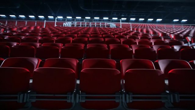 Camera dollies out to reveal empty seats in a basketball