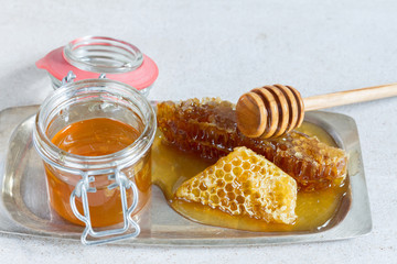 Honey in the jar. Honeycomb. Beige background.