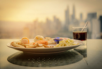 Breakfast dish and coffee at the roof of hotel with scenic Kuala lumpur city, Malaysia.