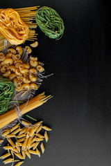 Mixed raw pasta on black background