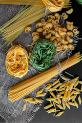 Mixed raw pasta on black background