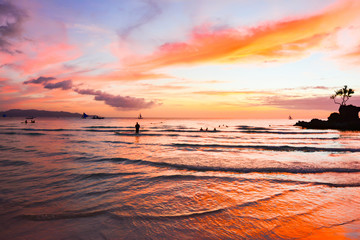 Colors at sunset in the ocean with wooden boats in the sea of the tropical island of Boracay in the Philippines