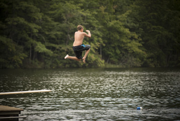 Fototapeta na wymiar Kid jumping on diving board