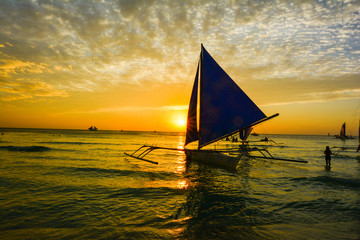 Sunset in tropical island of boracay with white beach and coconut palms in philippines