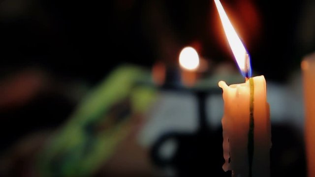 Burning candle against the background of female showing tarot card, magic