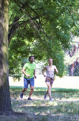 Young couple running in the park on a sunny day