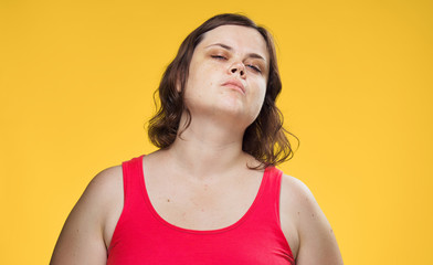 Fat woman on a yellow background, portrait