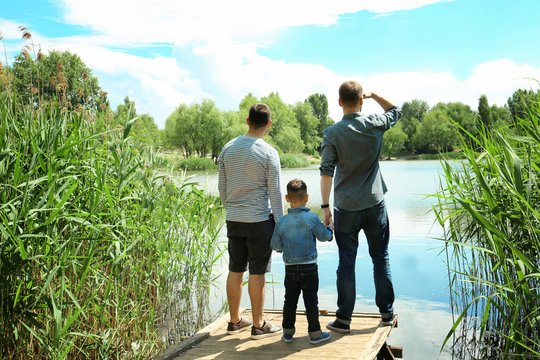 Gay couple with son on a pier