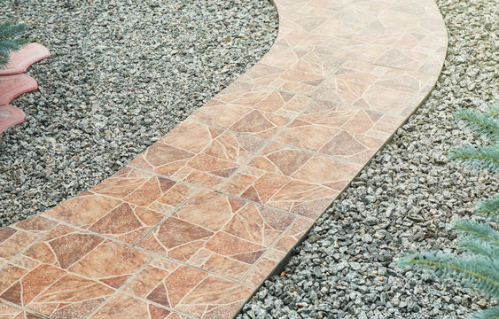 Pathway made from ceramic tiles with crushed stone in garden