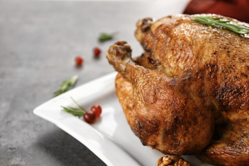 Plate with tasty whole roasted turkey on table