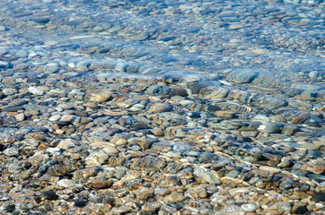 pebble stones into the water in the lake Baikal