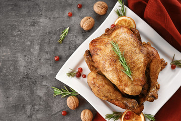 Plate with tasty whole roasted turkey on table