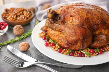 Plate with tasty whole roasted turkey on table