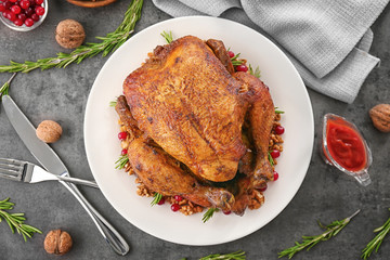 Plate with tasty whole roasted turkey on table