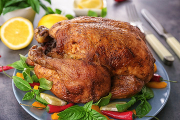 Plate with tasty whole roasted turkey on table