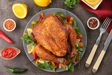 Plate with tasty whole roasted turkey on table