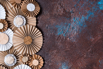 Craft paper flower rosettes on brown background