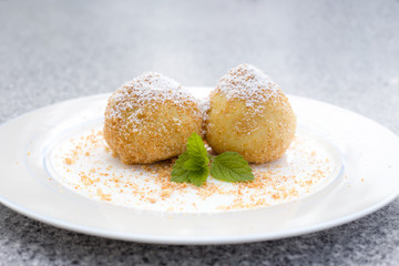 Vegane traditionelle österreichische Marillenknödel serviert auf einem Teller mit gerösteten Semmelbrösel