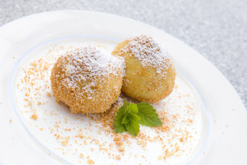 Vegane traditionelle österreichische Marillenknödel serviert auf einem Teller mit gerösteten Semmelbrösel