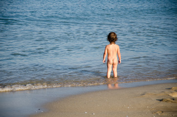 Child watching the sea on the beach