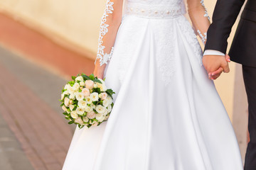 Groom holds bride's hand