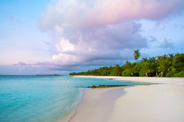 Landscape of beautiful sunset in Maldives island sandy beach with colorful sky over wavy sea