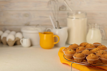Kitchen utensils, tools and products for the capcake (muffins) on a light wooden background.
