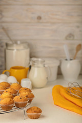 Kitchen utensils, tools and products for the capcake (muffins) on a light wooden background.