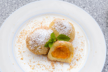 Vegane traditionelle österreichische Marillenknödel serviert auf einem Teller mit gerösteten Semmelbrösel