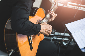 The musician is sitting guitar