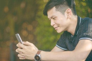 Attractive businessman using smartphone while sitting on sofa at his home.Concept of young people working mobile devices.Closeup with a selected focus.Blurred background. business.