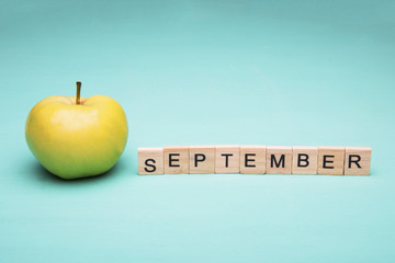 First september. Conception with apple and inscription on blue background.