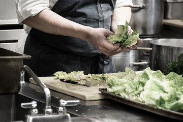 A prep chef, getting the salad ready for the Friday night dinner rush.
