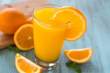 Fototapeta na wymiar Glass of Fresh Orange Juice With Slice on Side