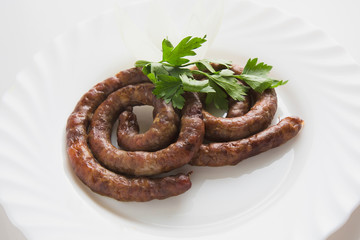 Grilled sausages with greens on the plate
