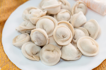 Frozen dumplings on the white plate with green
