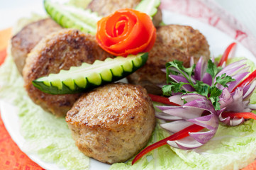 Beef cutlets with greens and vegetables on the plate