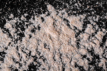 Pile of integral wheat flour isolated on black background and texture, top view, with clipping path