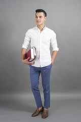 Portrait of man University student holding book in studio grey background
