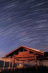 Starry night with star trail and blue sky and wooden Pavilion