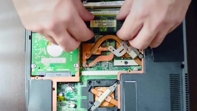 Replacement of RAM in the laptop. The man turns off the main memory card. Hands close up