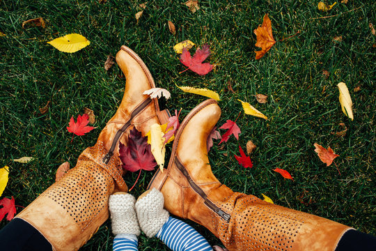 mother's boots and baby's booties in autumn