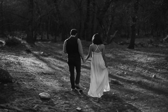 Couple eloping in Yosemite holding hands and exploring at sunset
