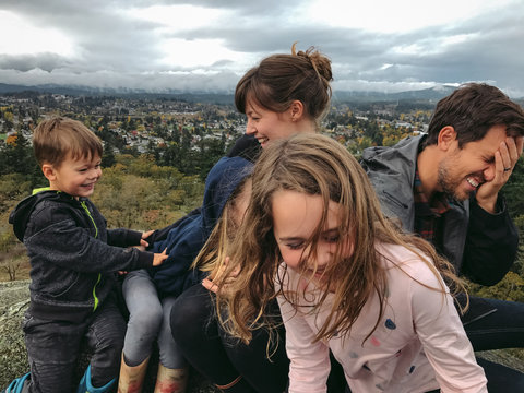 Young family goofing around together trying to take a group phot