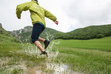 Male splashing water from a swamp on a rainy day