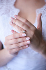 Vertical shot with bride's hands in focus, showing proudly the wedding or engagement ring. Wedding concepts, details, ideas and themes, bride morning preparation.