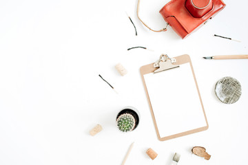 Clipboard with blank paper, retro camera, succulent, tools for handmade arts on white background. Top view, flat lay hipster artist concept.