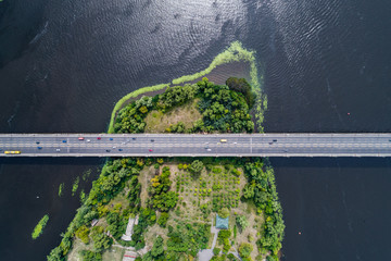 Aerial view of the bridge and the road over the Dnepr River over a green island in the middle of...