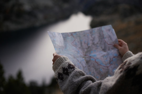 Female hands holding a map in a mountain valley